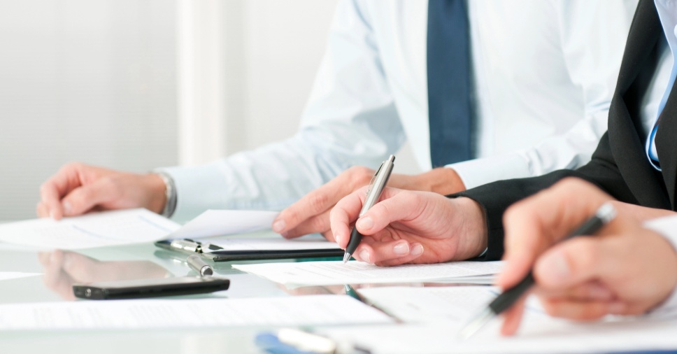 Reunião corporativa com análise de documentos sobre como agilizar o desembaraço aduaneiro