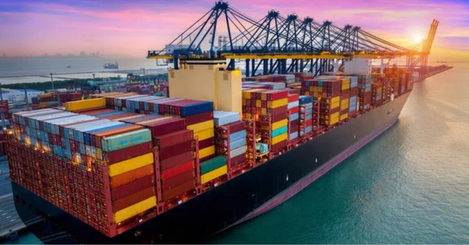 Visão de porto industrial e navio cargueiro descreve como funciona o transporte internacional de cargas.